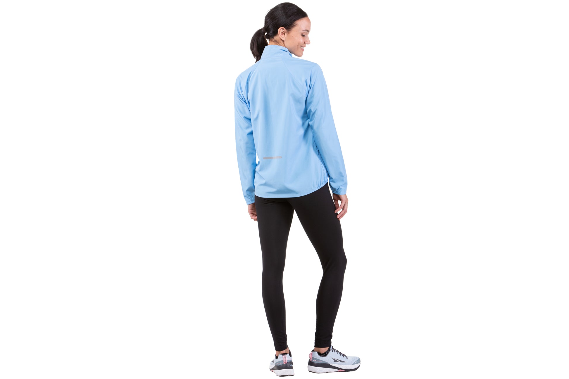 Women's Jacket - Core Running Jacket by Ronhill, in Cornflower Blue colour. This jacket is lightweight, wind proof and shower resistant. The collar is fleece-lined, for additional comfort on chilly days. The cuffs and hem are semi elasticated for a neat finish, and the front zip security pocket is easy to access. Back view of a person wearing the jacket.