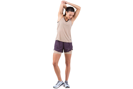 Women's Shorts - Women's Tech Ultra Twin Shorts by Ronhill. Made from recycled materials and boasts 10 pockets and 2 storage loops. A lightweight ventilated mesh inner keeps you cool in hot conditions. The material is breathable and has wicking. These shorts are in a nightshade colour and the photo shows the front view of a person wearing them